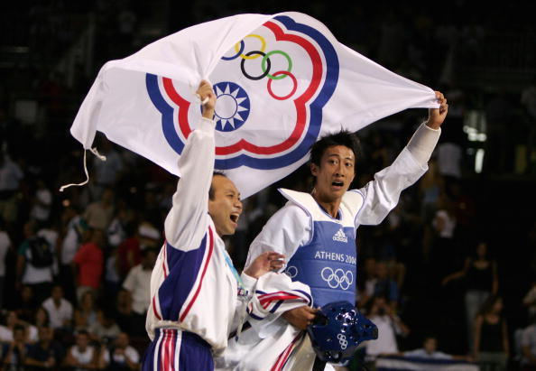 ATHENS - AUGUST 26: Mu Yen Chu of Chinese Taipei celebrates with his coach after winning the gold medal with his defeat of Oscar Francisco Salazar Blanco of Mexico in the men's under 58 kg Taekwondo gold medal match on August 26, 2004 during the Athens 2004 Summer Olympic Games at the Sports Pavilion part of the Faliro Coastal Zone Olympic Complex. (Photo by Al Bello/Getty Images)