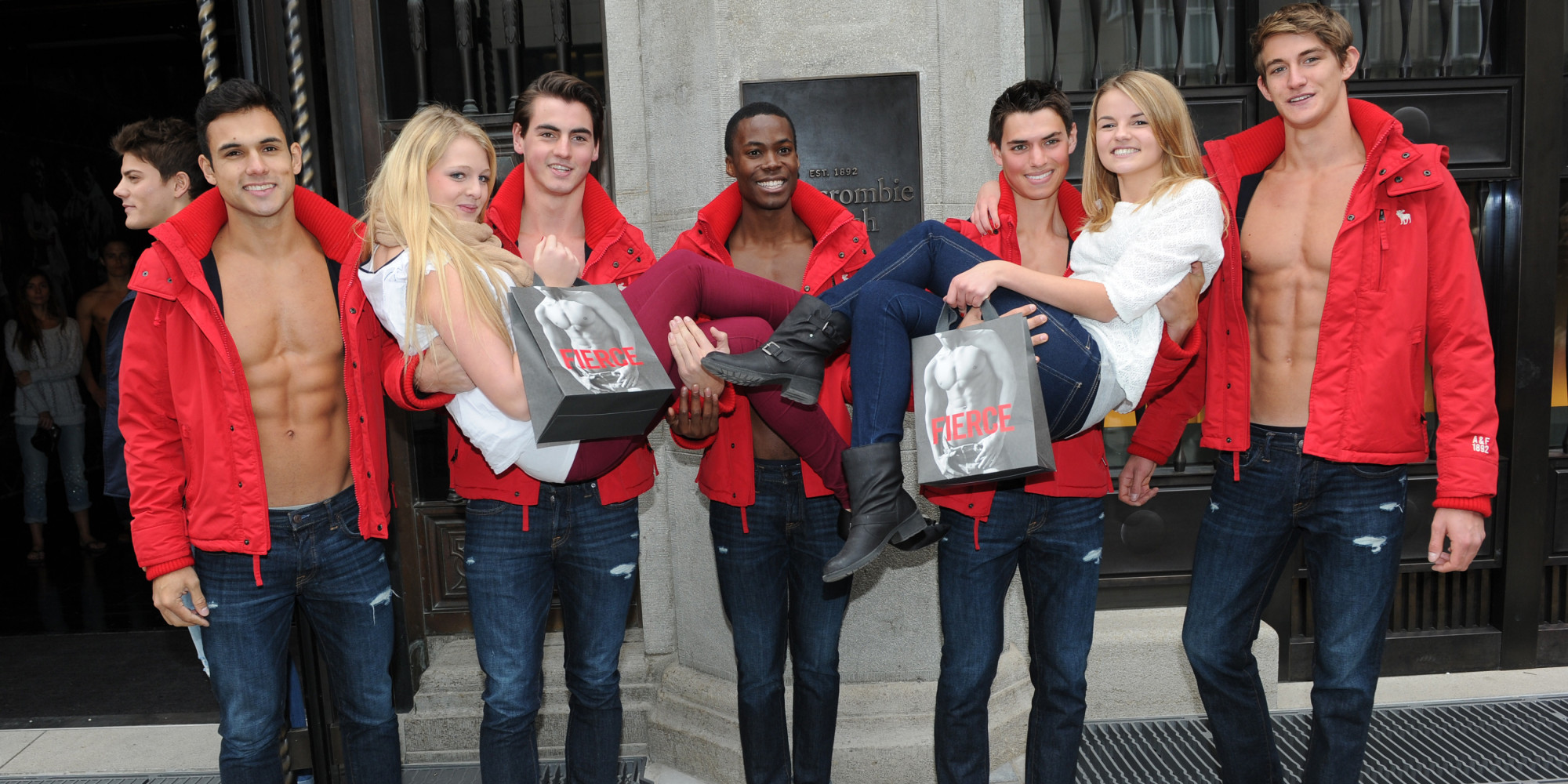 MUNICH, GERMANY - OCTOBER 25: Young women pose for photographs with male models outside the Abercrombie & Fitch flagship clothing store during the opening of Abercrombie & Fitch Munich flagship store on October 25, 2012 in Munich, Germany. (Photo by Hannes Magerstaedt/Getty Images)