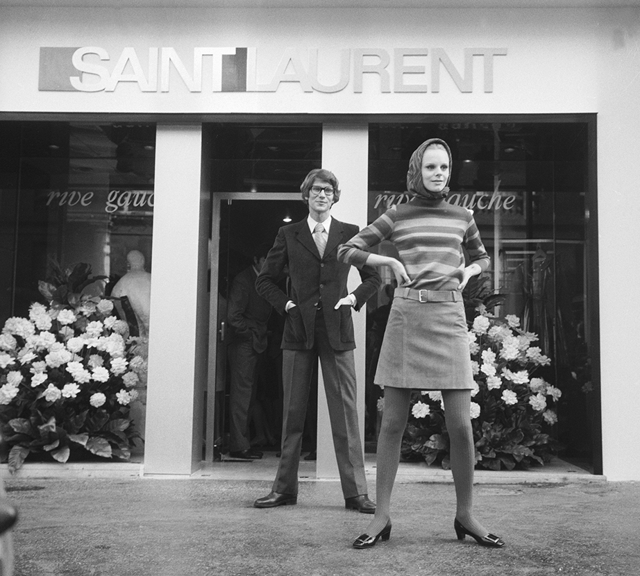 Yves Saint Lauren and Swedish model Ulla in front of his Paris Saint Laurent Rive Gauche boutique.