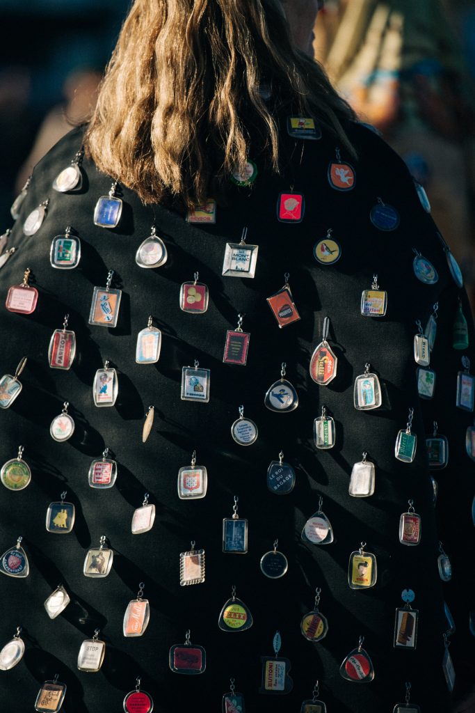 Model wearing coat with badges